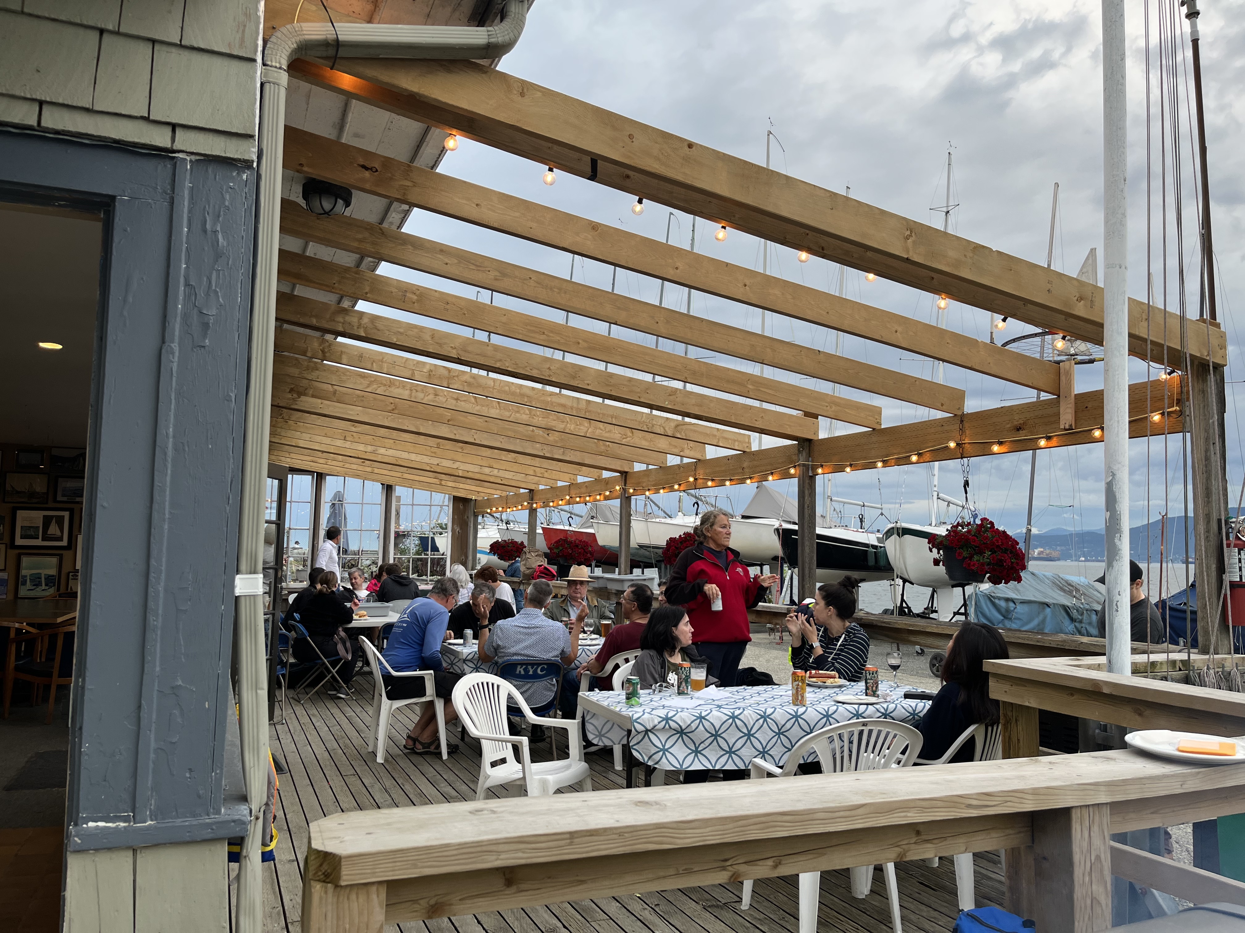 Sailors and guests sharing an outdoor meal at Kitsilano Yacht Club at sunset