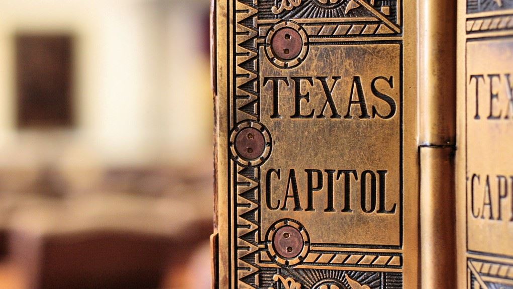 Hinges on a door, artistically engraved with the words Texas Capitol