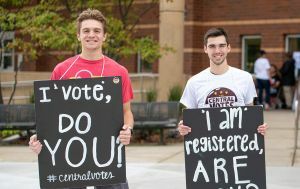Young men holding vote signs