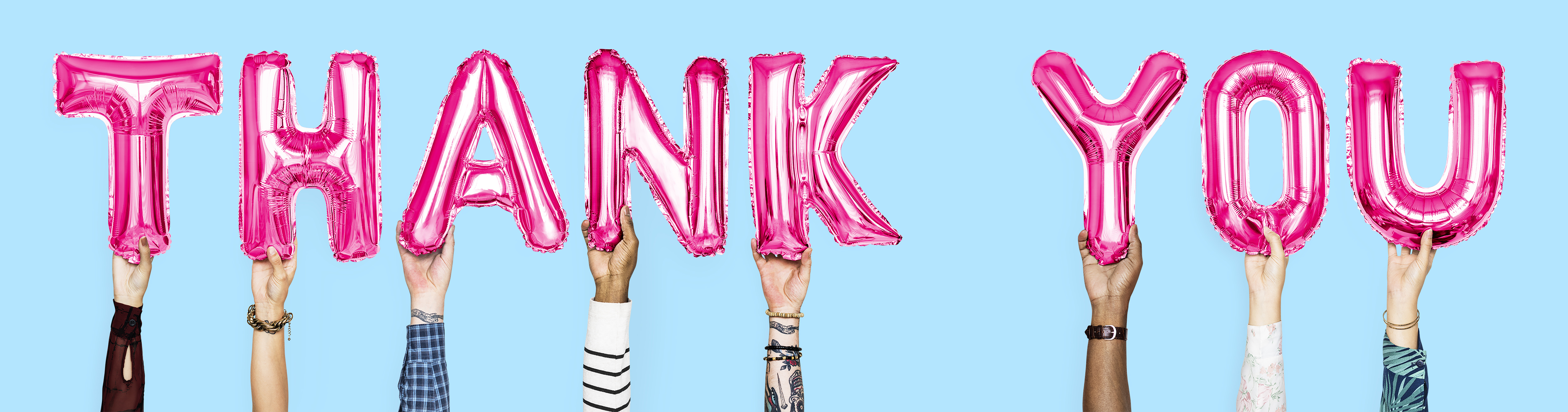 Hands holding balloons spelling thank you
