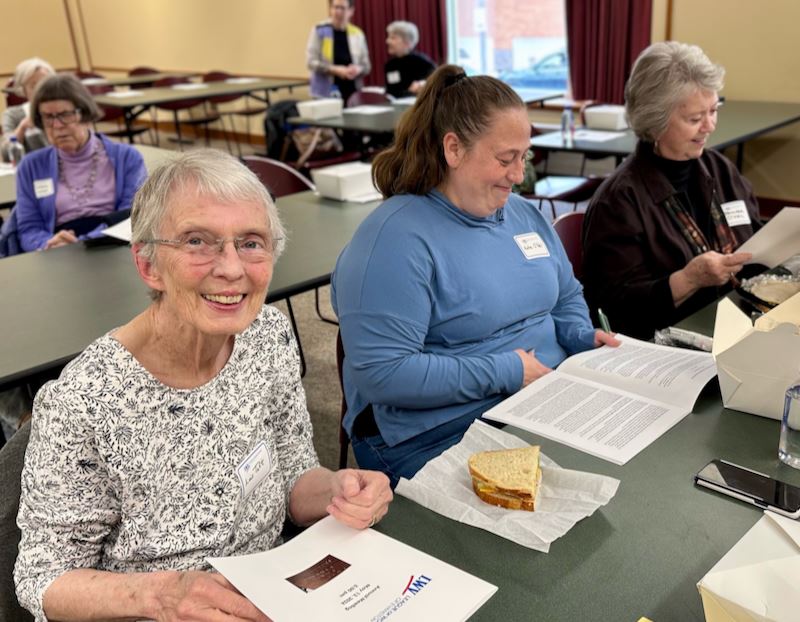 Lois, Katie, and Jennifer reading the Annual Report