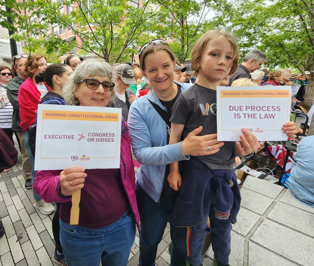 LWVE member and friends with LWV signs defending democracy.