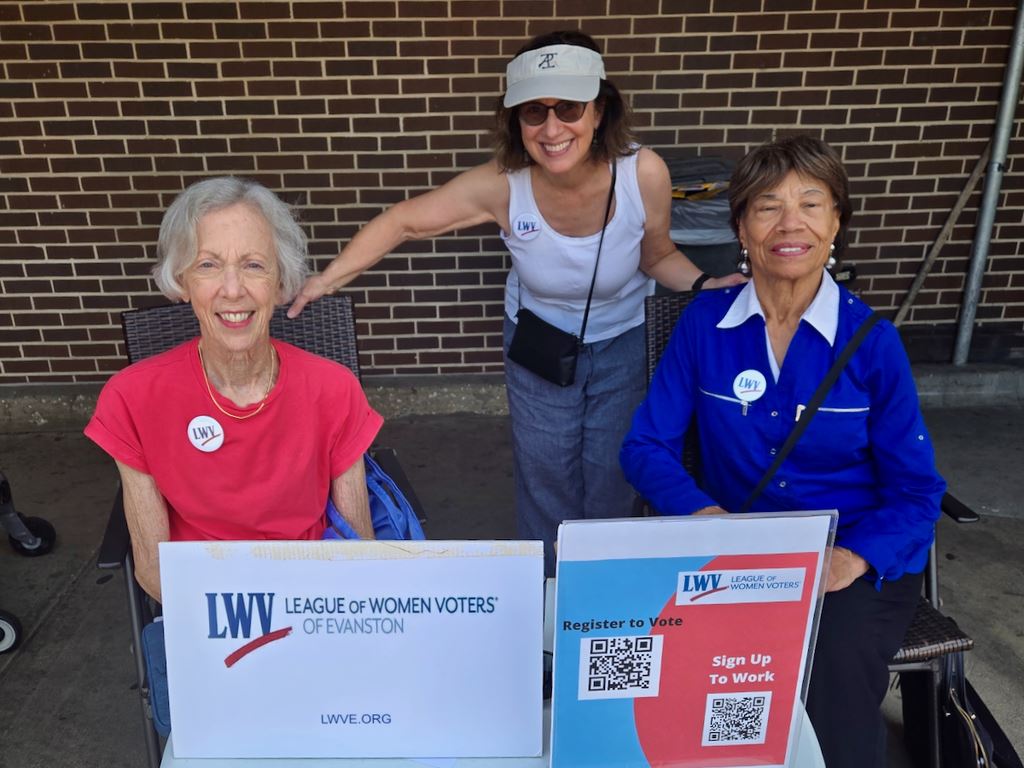 Sue Calder, Beth Demes, and Gerri Sizemore offer voter registration and info at Vallis Producee