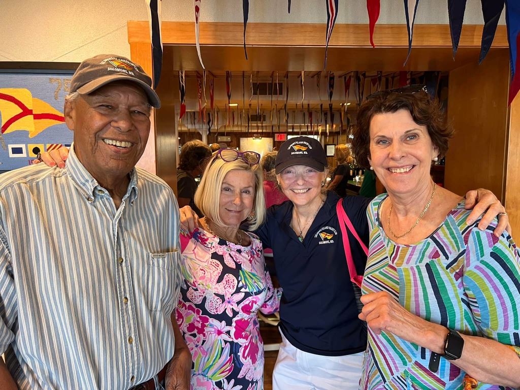 A man and three ladies arm in arm