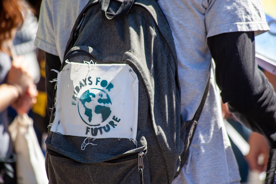 Student with backpack and backpack has Fridays for Future sign on it