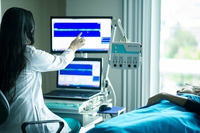 Hospital room with nurse checking electronic equipment