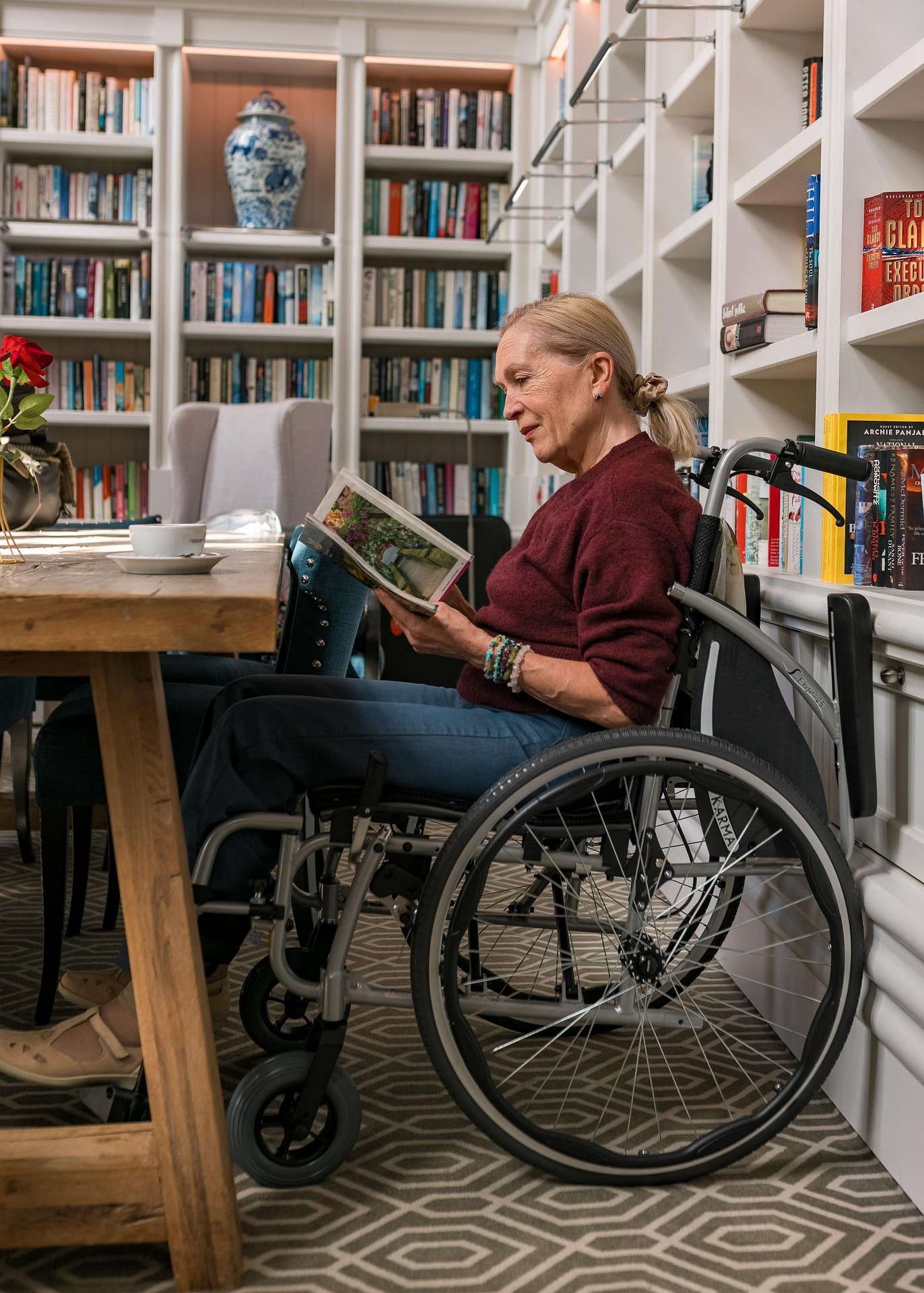 Woman in wheelchair in library reading