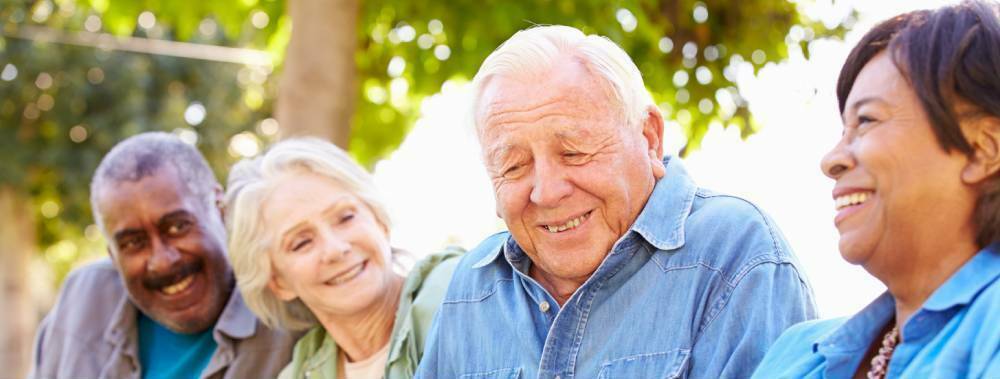 Four older adults laughing and sharing