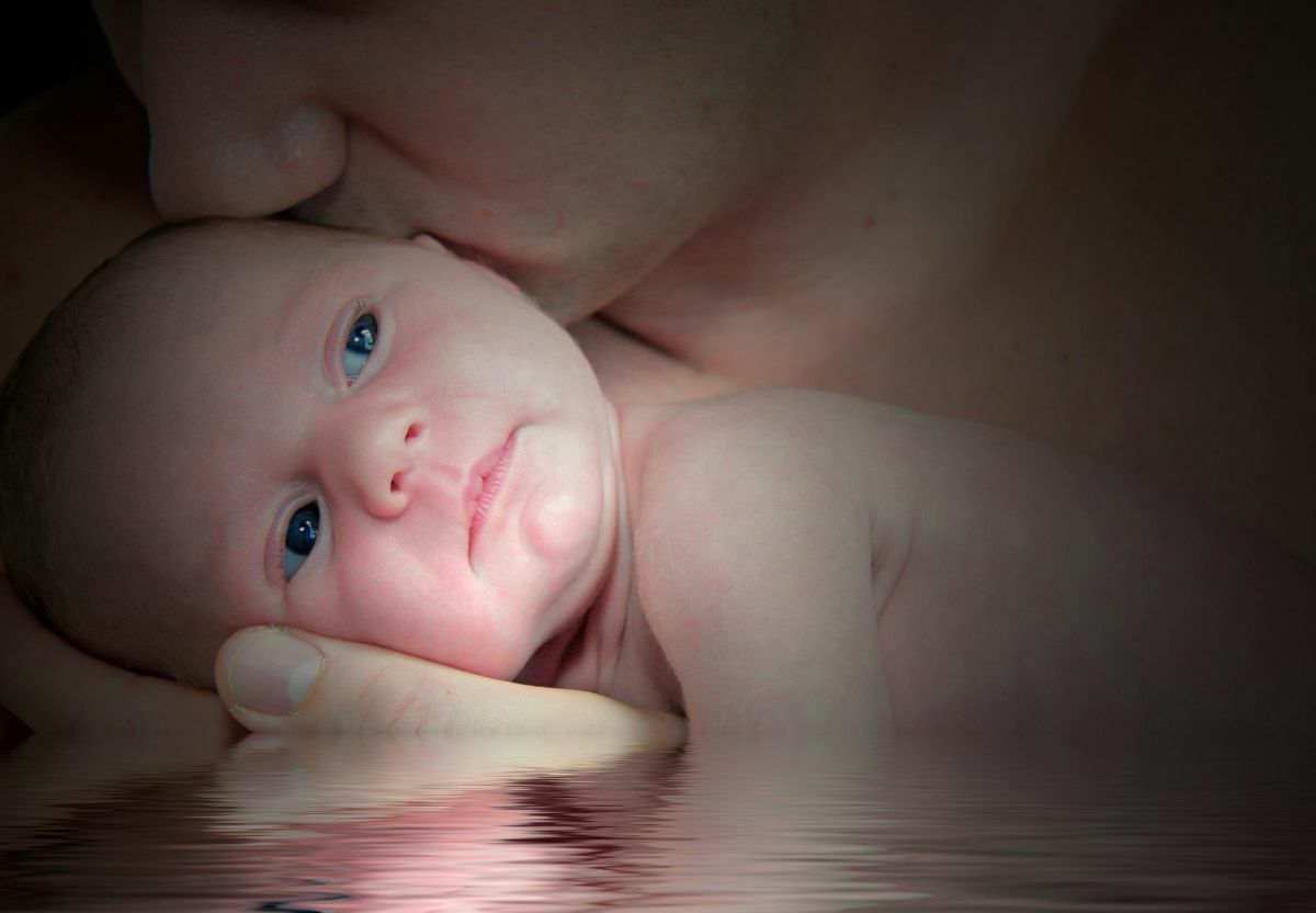 Tender moment of parent cradling newborn baby, illustrating the intimate bond and welcoming atmosphere of a baby blessing ceremony