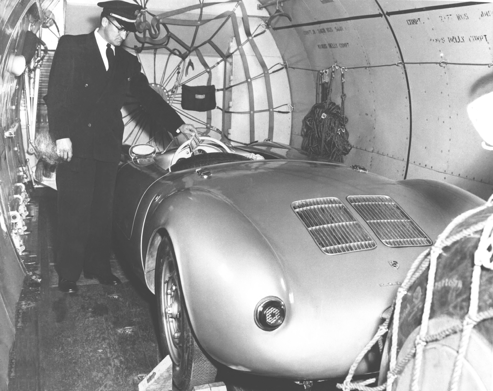 Porsche_Period_Photos_-_Singer_-_Batch_1-31_550_Spyder_in_airplane_for_1955_Carracas_VZ_race..png