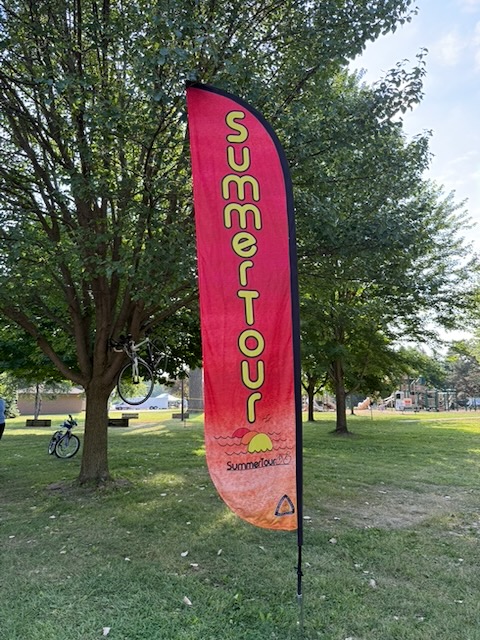 ST 2026 SummerTour feather banner with bike in background