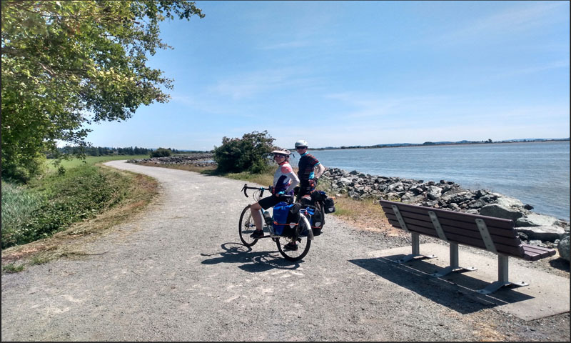 bikepackers ride near the water