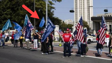 Crowd displaying many flags, including US, Trump and Turkistan