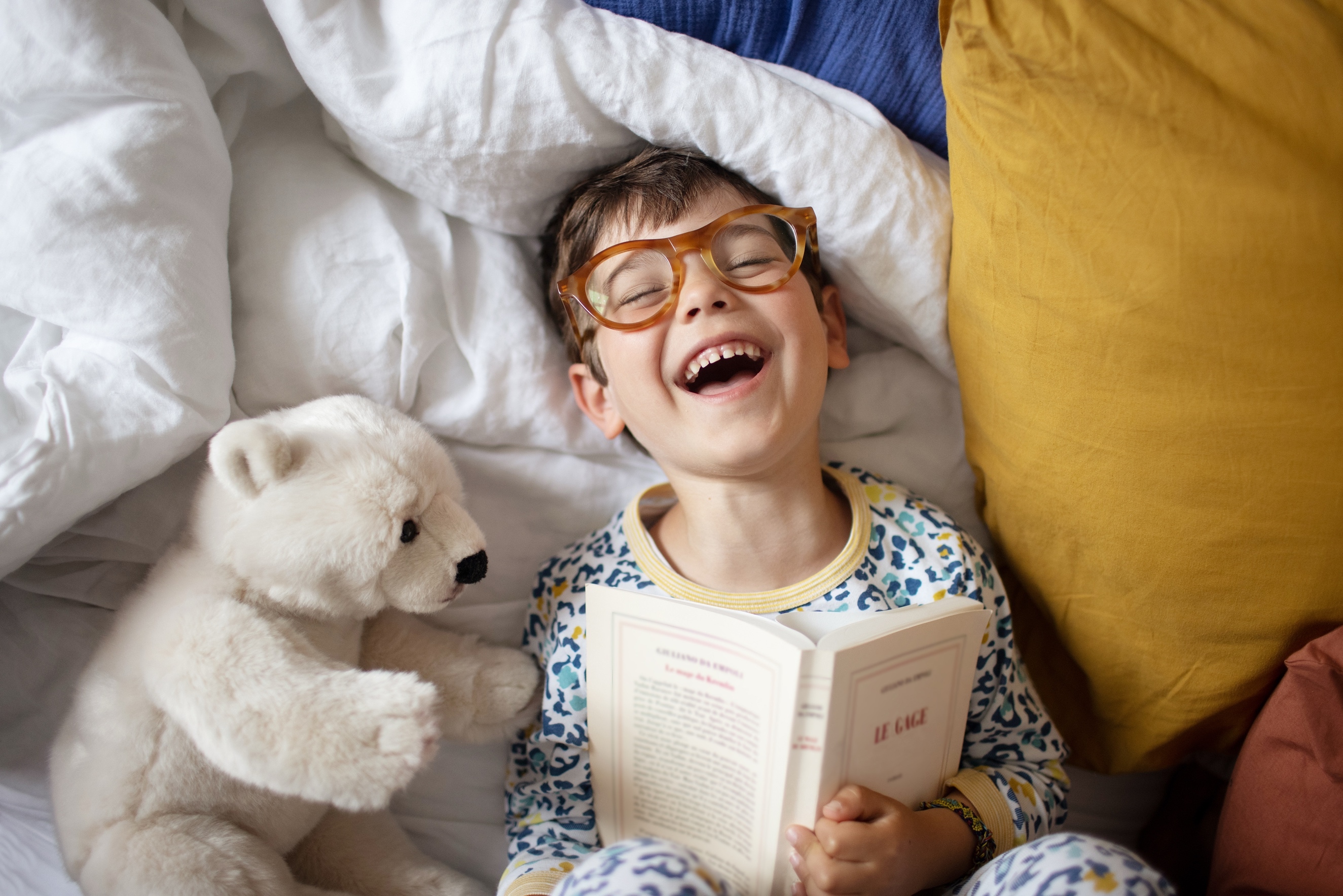 young child reading in bed